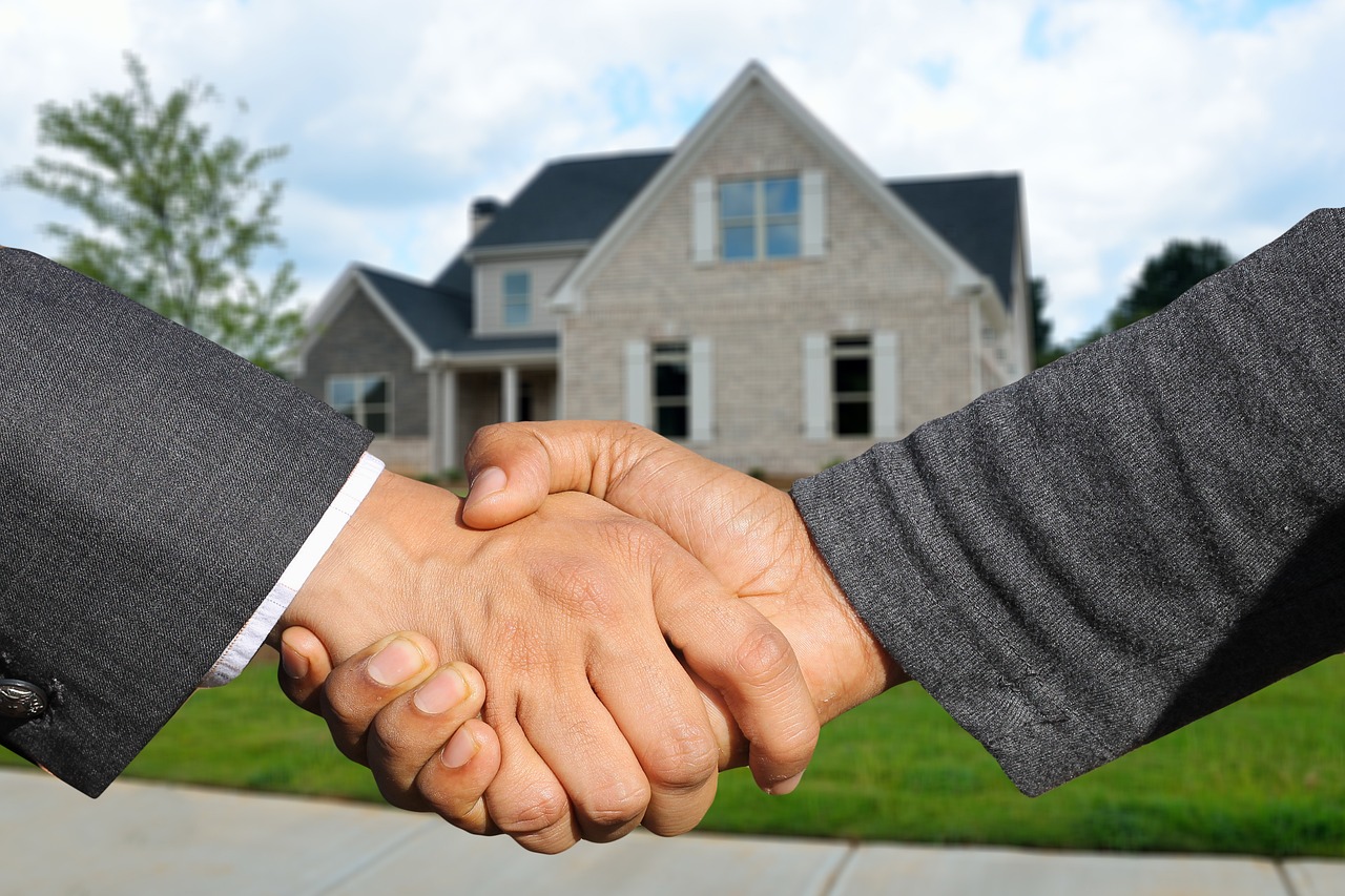 Agente inmobiliario entregando llaves a su cliente tras cerrar la operación