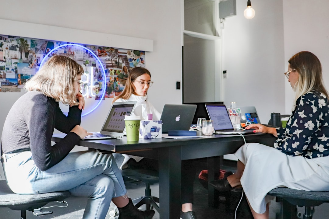 digital marketing team office - 3 women sitting on chair in front of table with laptop computers