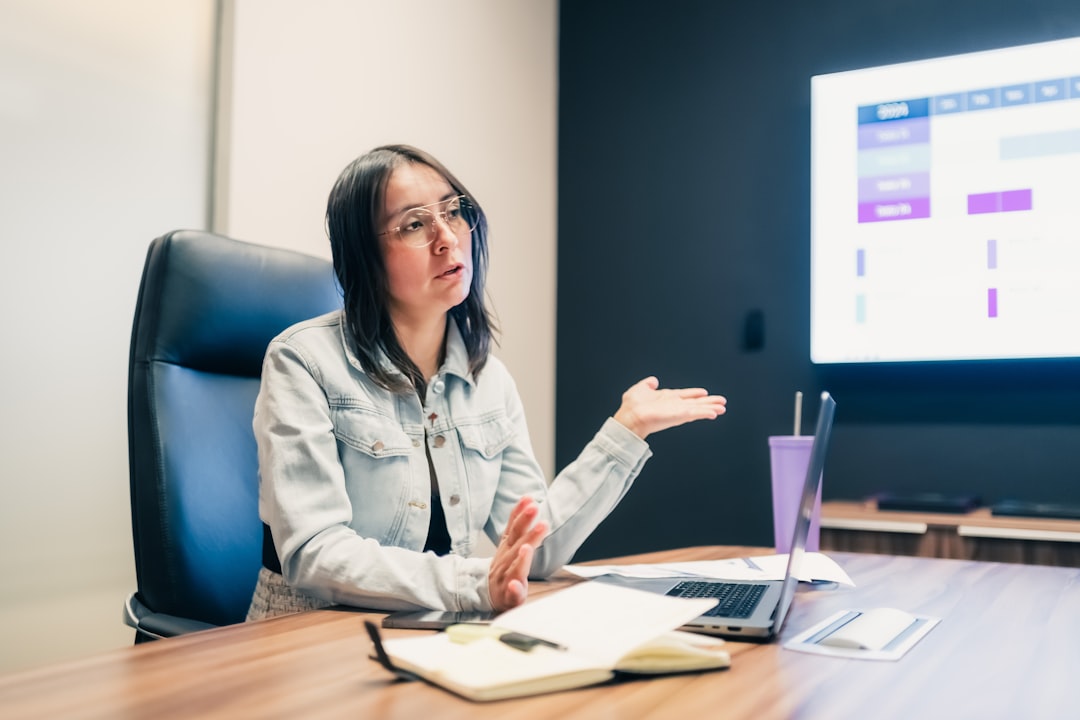 Monitorización de marca con IA en 2026: análisis de competencia y price tracking 3 team meeting strategy office - Woman gestures while explaining something at a presentation.