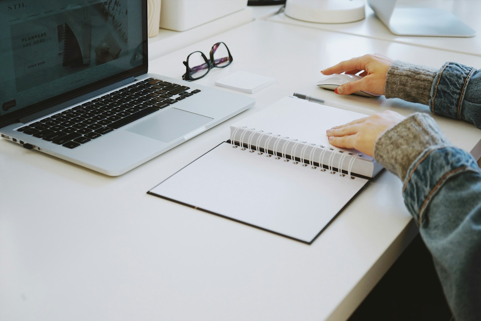 Diseño de Flujos de Trabajo: Crea tu Flujo de Trabajo de IA Personal (Curso de Claude – Lección 12) 1 Profesional diseñando su flujo de trabajo con IA en un cuaderno junto al ordenador